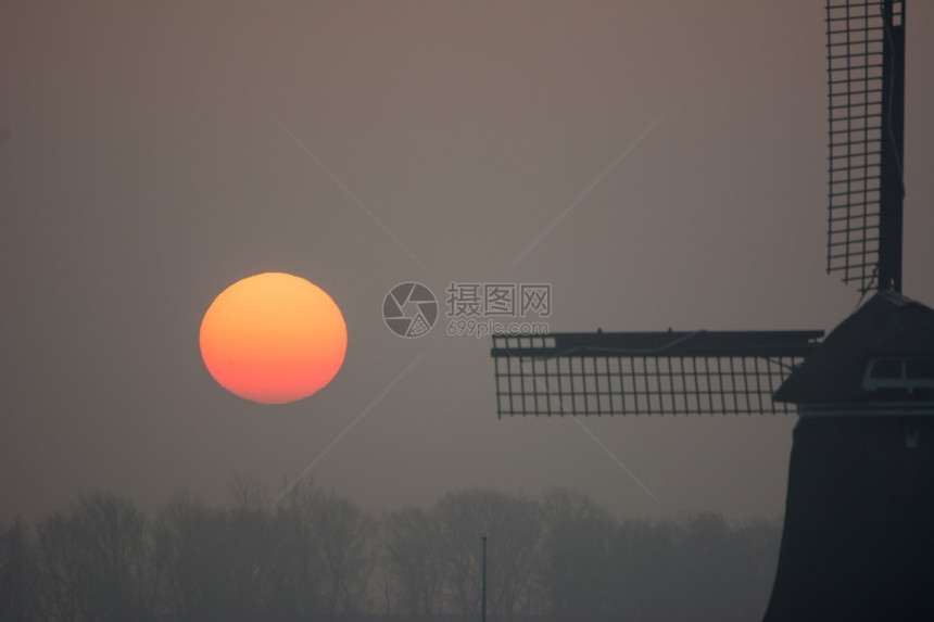 日出雾寒冬清晨与风车场地早建筑物图片