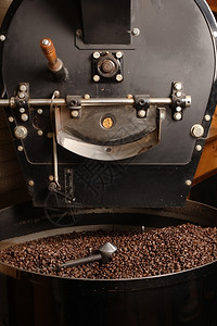 在冷却气瓶中搅拌一个大型老式咖啡烘烤机的新鲜烧咖啡豆屋馆酿造图片
