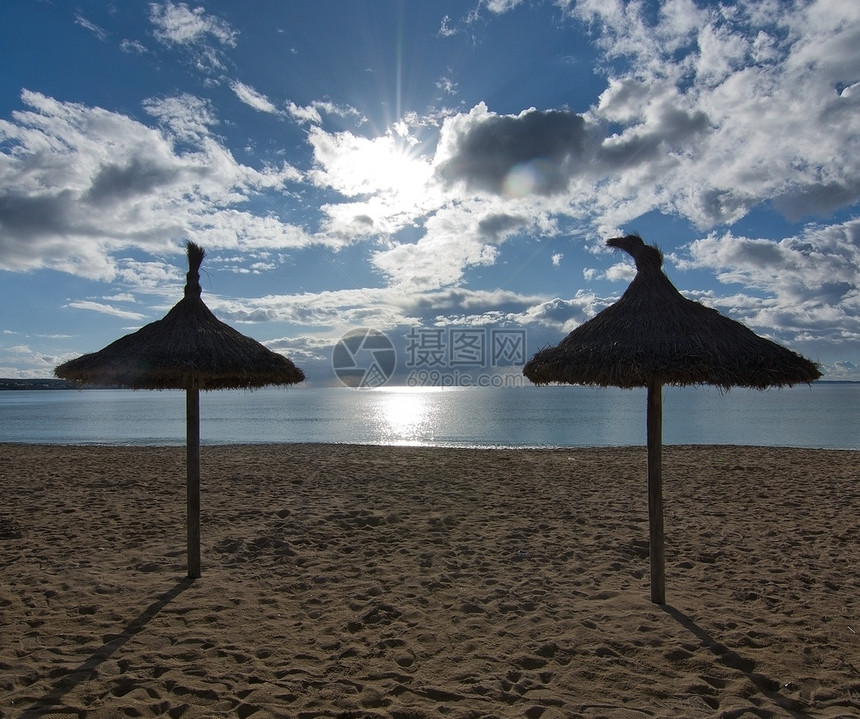 阳光明媚的沙滩上的遮阳伞图片