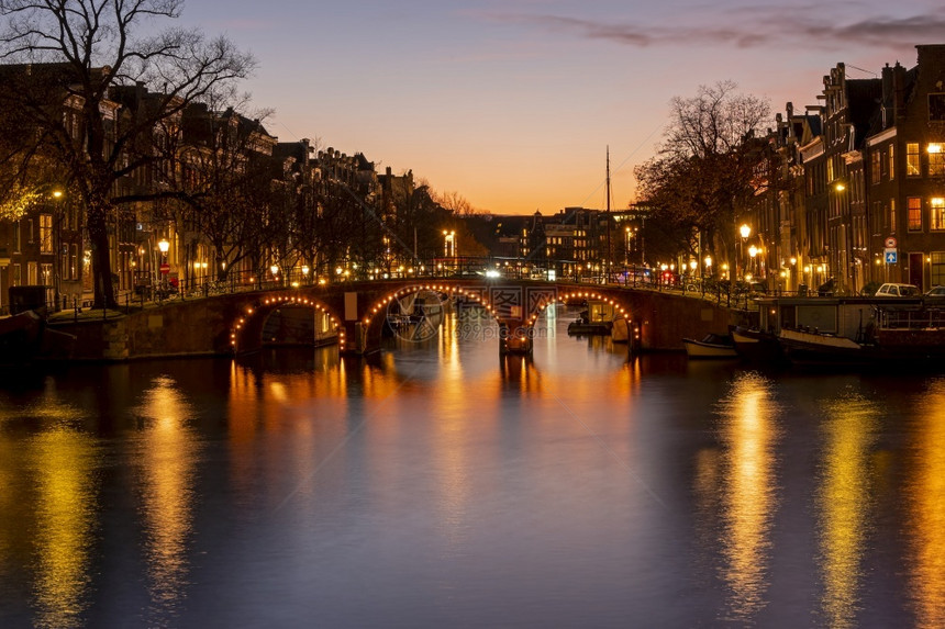 历史日落时在荷兰阿姆斯特丹尔河市风景建筑物历史的图片