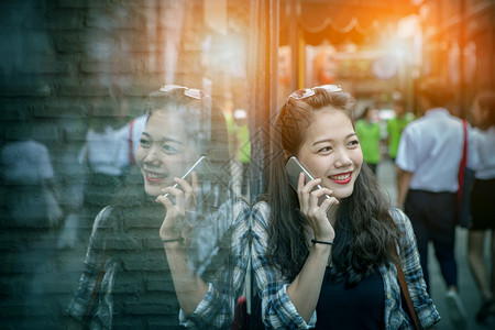 假期年轻亚洲女肖像与智能手机交谈用快乐的情感微笑着脸交流电话图片