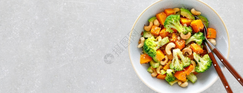 健康核桃蔬菜沙拉碗花椰烤南瓜鳄梨和坚果油图片