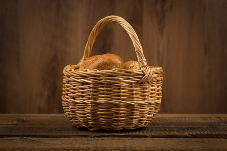 美食品种各面包木制桌上的烘烤产品篮子图片