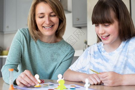 母亲和女儿在家中玩普通板游戏乐趣水平的家庭图片