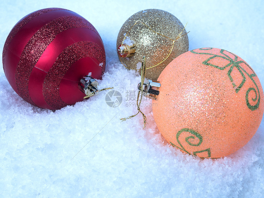 新年背景三个不同颜色的圣诞球在雪中的新年背景有色快乐的横幅图片