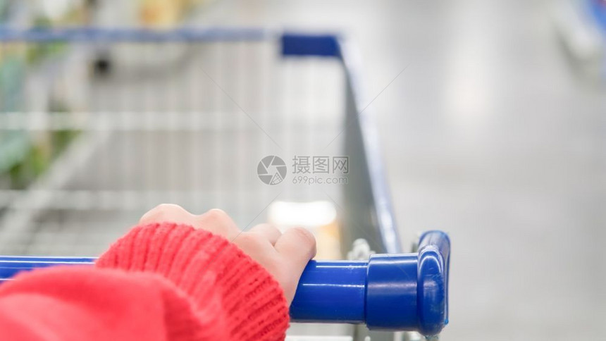 超市百货商店的移动模糊电推车女客型买城市篮子图片