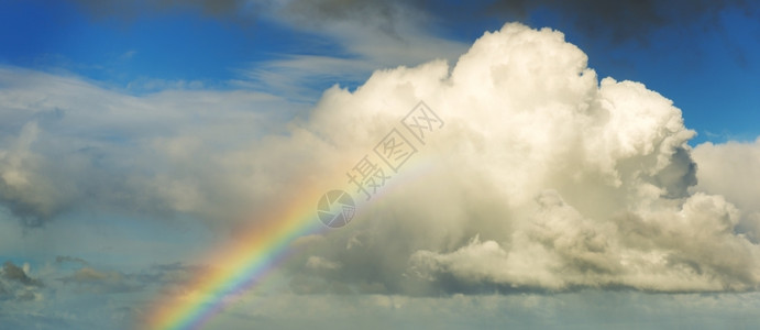 彩虹以明亮的颜色升起至蓝天空的大白云山澳利亚绿色图片