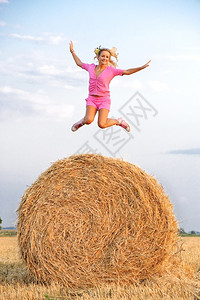 女士运动鞋干草金发女孩在田地上跳高图片