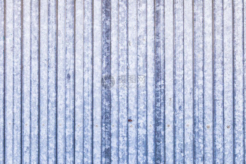 划伤老的蓝色生锈金属门带白建筑的图片