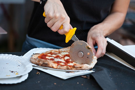 切贝利奶酪工具煮熟的披萨制造者切薄饼玛格荷莉塔切成一片准备带走披萨制造者切玛格丽塔背景