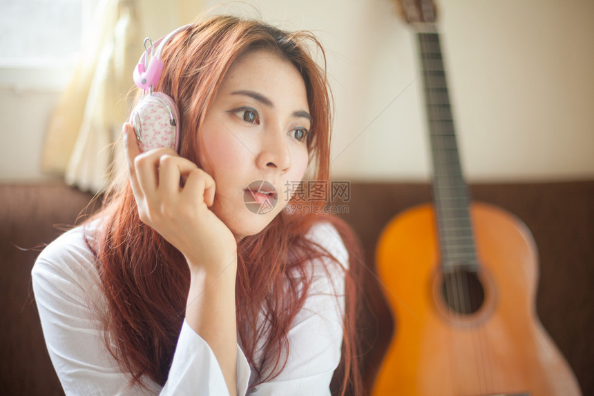 年轻的亚洲美丽年轻女士听音乐微笑女孩图片