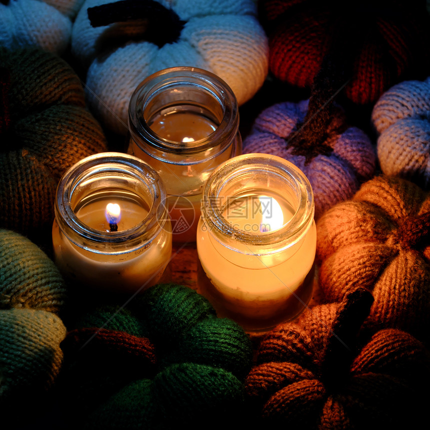 闲暇手工制作的红色美丽编织南瓜来自有三根蜡烛的缝线夜间三根蜡烛光造就了丰富多彩的背景休闲活动制作的精美手工产品图片