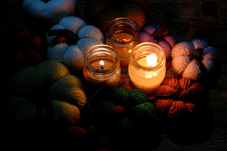 蓝色的美丽编织南瓜来自有三根蜡烛的缝线夜间三根蜡烛光造就了丰富多彩的背景休闲活动制作的精美手工产品黄色的金图片