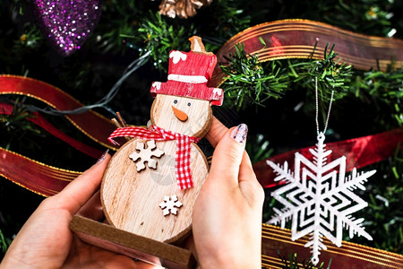 手握着圣诞雪人雕像在圣诞树前的装饰被隔离的fir树塑像圣诞节雪花图片