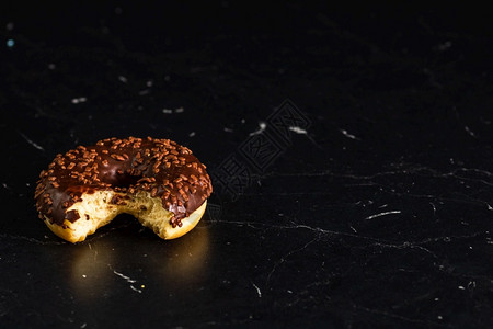 新鲜美的彩色甜圈黑底喷洒卡路里美国人味的图片