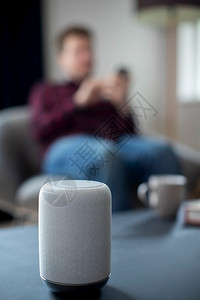 连接的技术器具Man串流音乐或播客到家里手机上的智能演讲人图片