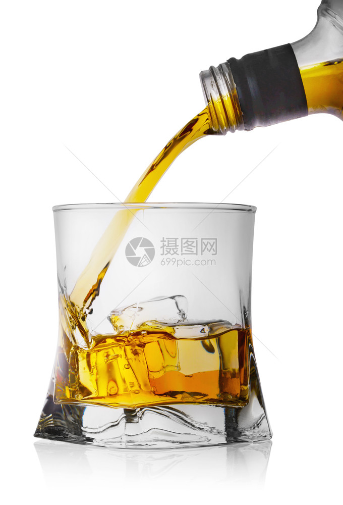 威士忌从瓶子倒到玻璃杯中冰在白色背景上隔绝的冰面威士忌从瓶子倒到有冰的玻璃杯中目立方体黄色图片
