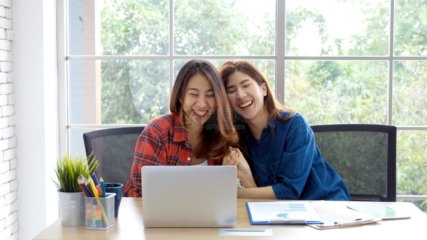 两名在家庭办公室用笔记本电脑工作情绪快乐在家工作小企业办公室临时生活方式概念的年轻女青她们有2名青女美丽的快乐女士图片