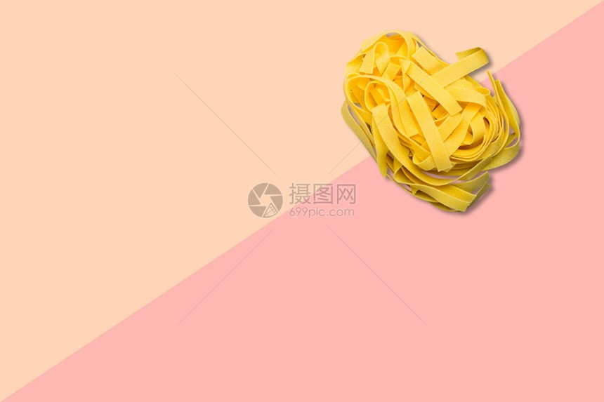 丰富多彩的生黄色近距离观察被粉红背景孤立的意大利原面图片