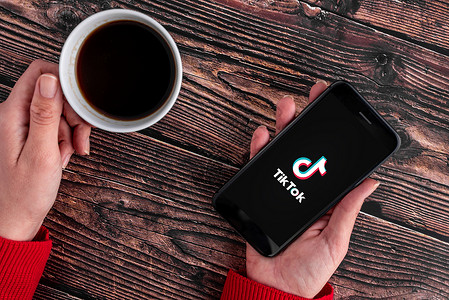 安卓1素材20年5月1日的智能电话显示Tiktok应用程序标志Tiktok应用程序徽标人苹果手机安卓背景
