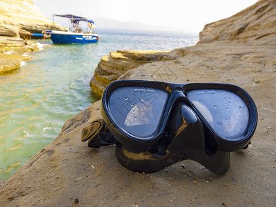 适用于近海蓝色的靠近用于在海岩石上进行水肺潜的面罩用于在近海岩石上进行水肺潜的面罩支撑背景