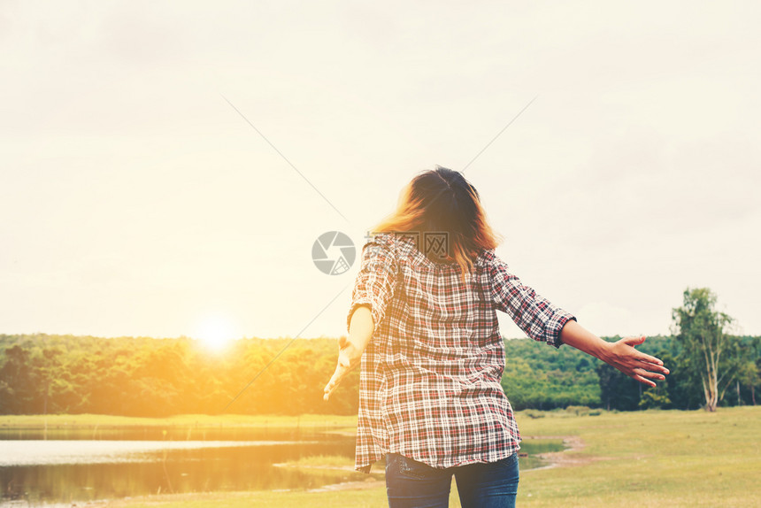 女生活方式概念年轻美女伸手在空气中享受大自然外的新鲜空气女生活方式概念年轻美女伸手公园成功坐着图片