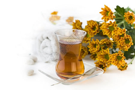 叶子绿色白背景的一杯草药茶和鲜花毛巾图片