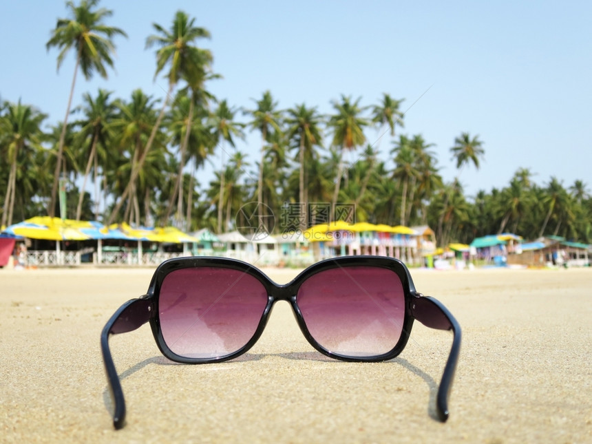 屋树人们印度南果阿部Palolem海滩沙上的太阳镜图片