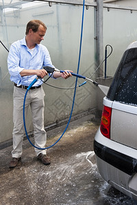 男人用高压喷水雾自己洗车的时候把推下来软管中间灯图片