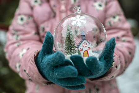 小女孩拿着圣诞玻璃球特写背景图片
