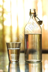 桌子下午玻璃瓶和桌上杯子中的清水移动图片