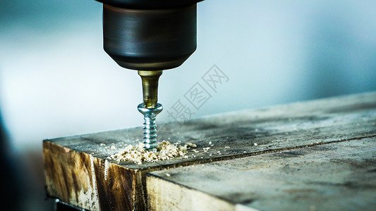 钻头螺丝刀行业乐器工具近距离拍摄一名男子用电手钻孔螺丝插在木板上Aspecet比169背景