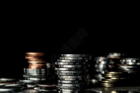 货币黑暗背景上堆放着不同的硬币节省银行业图片