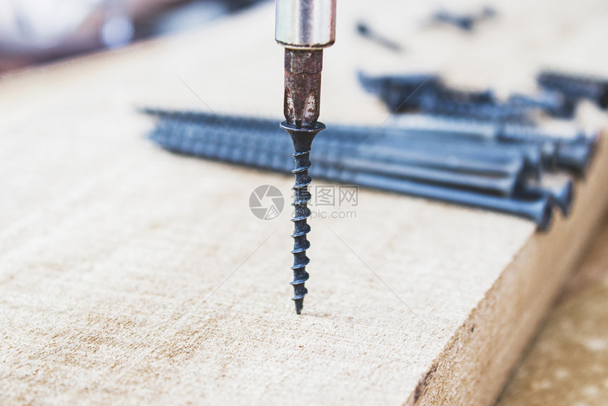 螺栓钻头用丝刀将钢拧入木板工具和维修作的概念钢螺丝金属用刀将钢拧入木板钢螺丝手图片