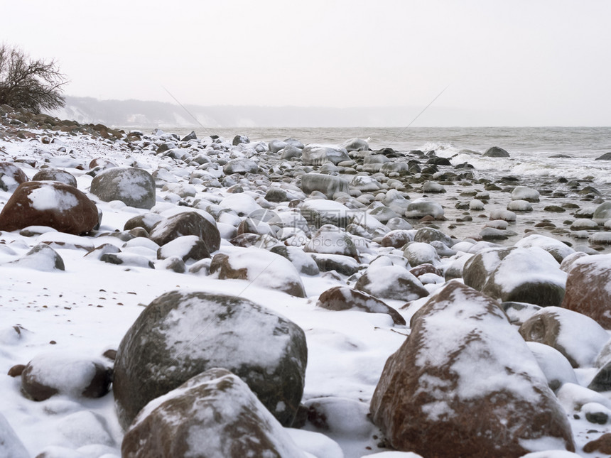土地冬天的岩石海岸上的岩石被雪覆盖海岸上被雪覆盖的海岸冬天岩石海岸晚上仙女图片