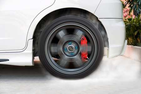 车轮在赛道上展示燃烧轮胎的赛车橡胶细节图片