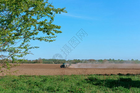 工作拖拉机在田里耕作职的播种图片