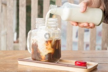 挤牛奶到冰的咖啡杯股票照片立方体营养喝图片