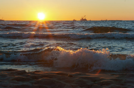 金子海滩宁静上日落浪中的出上落图片