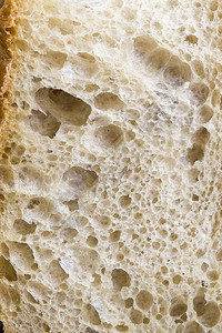 由低质量面粉烤制成的软包在屑中剪切了一半的缝合新鲜面包吃脆的崩溃图片