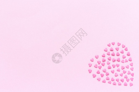 心糖藤玻璃瓶平坦的抽象婚礼粉红色糖果的心洒在形上位于柔和的粉红色背景右上角概念Valentinersquos卡顶视图复制文本空间设计图片