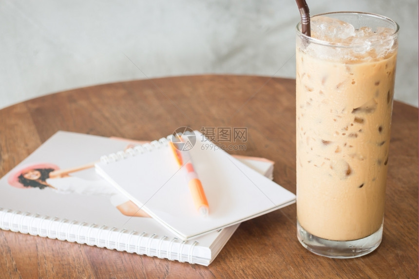 凉爽的木制喝工作桌上的冰咖啡杯库存照片图片