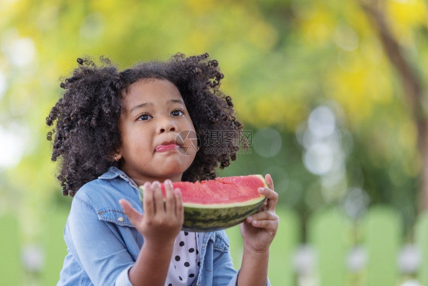 非洲裔黑人女孩对一小片西瓜很满意快乐的头发图片