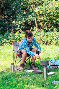 青年男子在帐篷旁边做饭图片