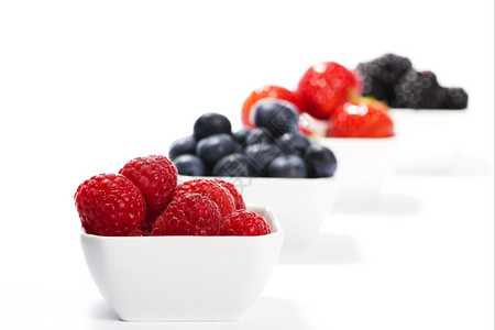 黑色的自然在野生浆果前的树莓碗里有草在野生浆果前面有白本底的碗蓝莓图片