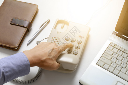 具有办公室背景的商人拨号数字电话有办公室背景的数字电话手指连接技术图片