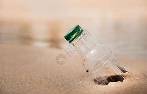 沙滩上的塑料瓶背景图片