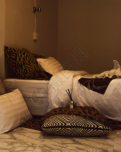 木制的枕头和毯子在床上有温暖的灯光枕头和床毛毯在上放松窗户图片