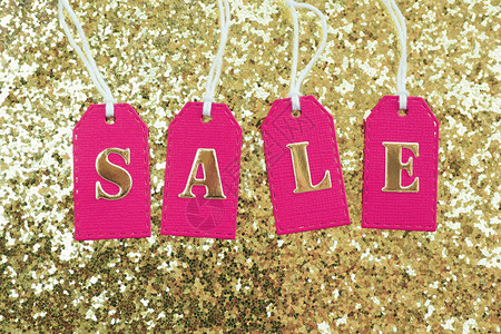 圣诞节晴天绳索在粉红色标签上以金字母出售白绳在有闪光的金本底色背景上图片