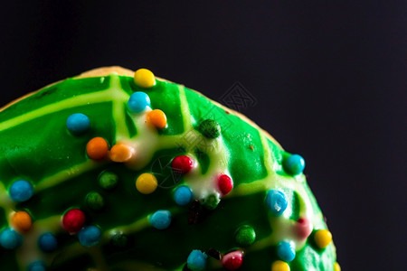 什锦的奶油食物绿面甜圈上有零散的喷洒贴近彩色甜圈图片